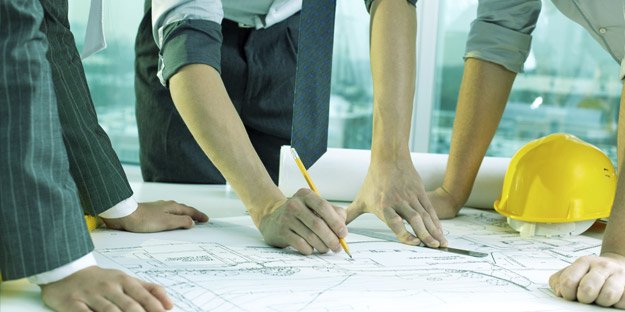 Altruent Systems team planning a data center project over blueprints